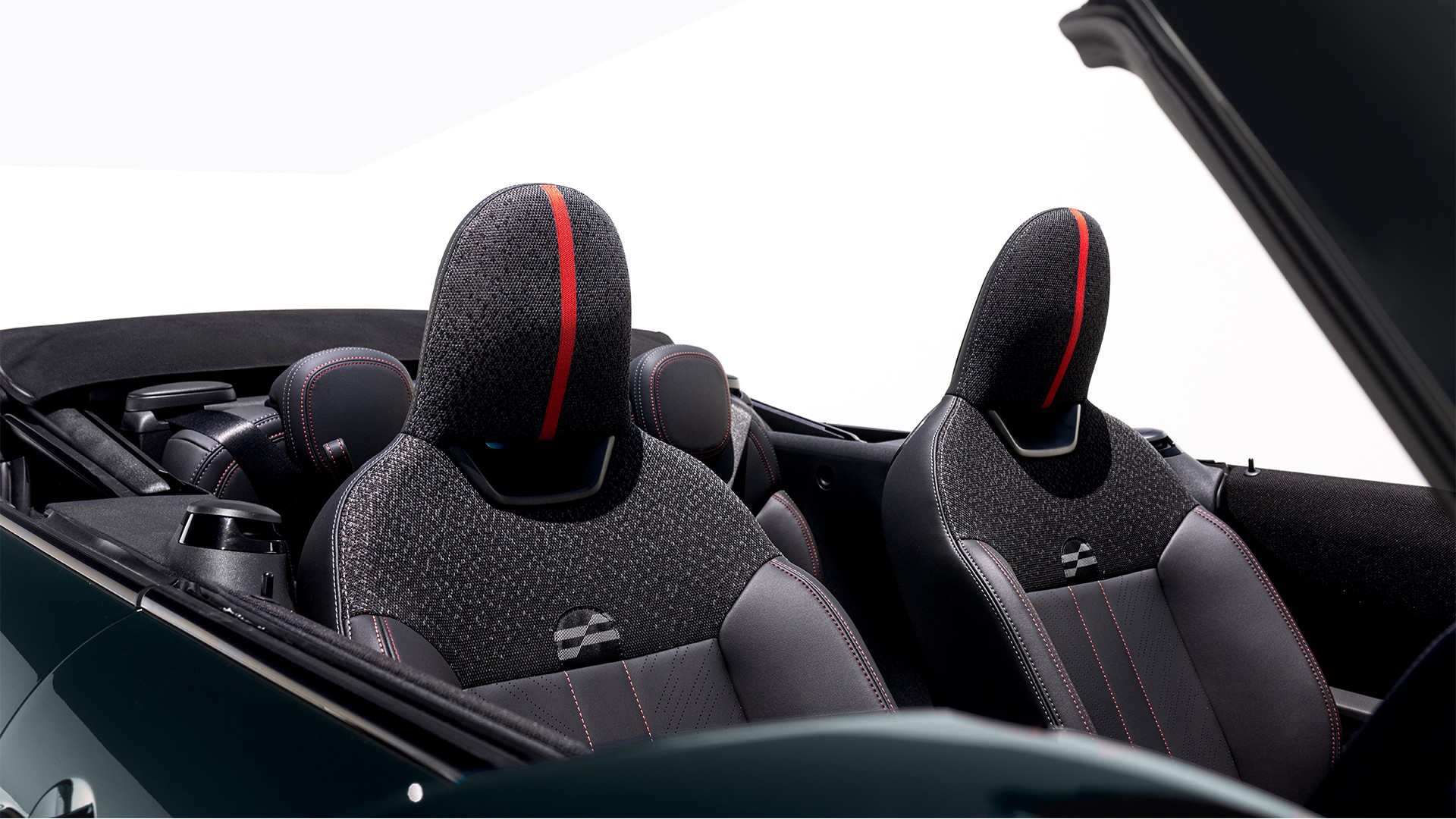 Rear left view of a parking MINI Cooper Convertible at the beach with two people